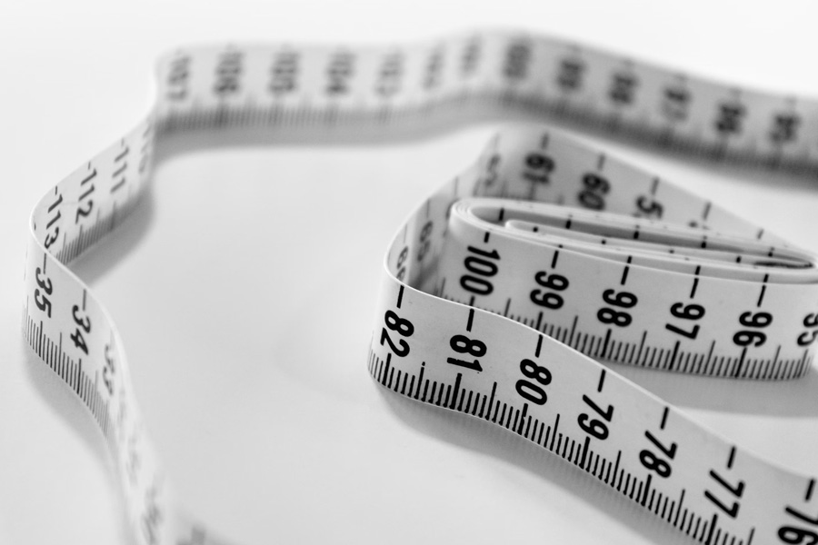 A white tape measure, representing the tracking of progress and goals in weight management